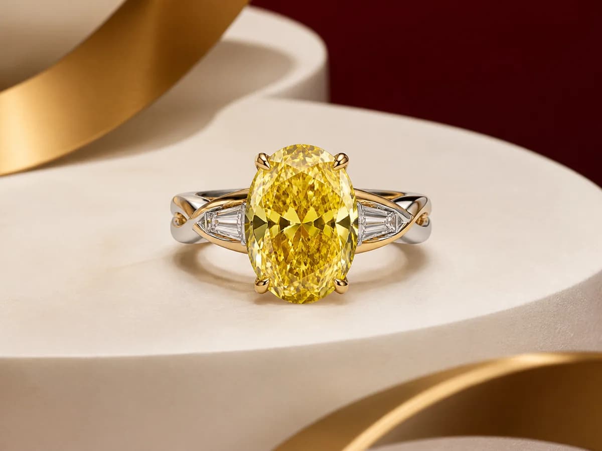 Illustrative people-free jewelry still life with a yellow oval laboratory-grown diamond direction and a complementary elongated-oval ring setting