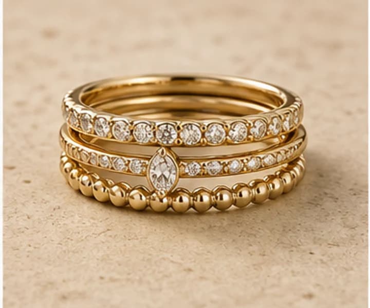 Illustrative coordinated stack of three gold and diamond rings