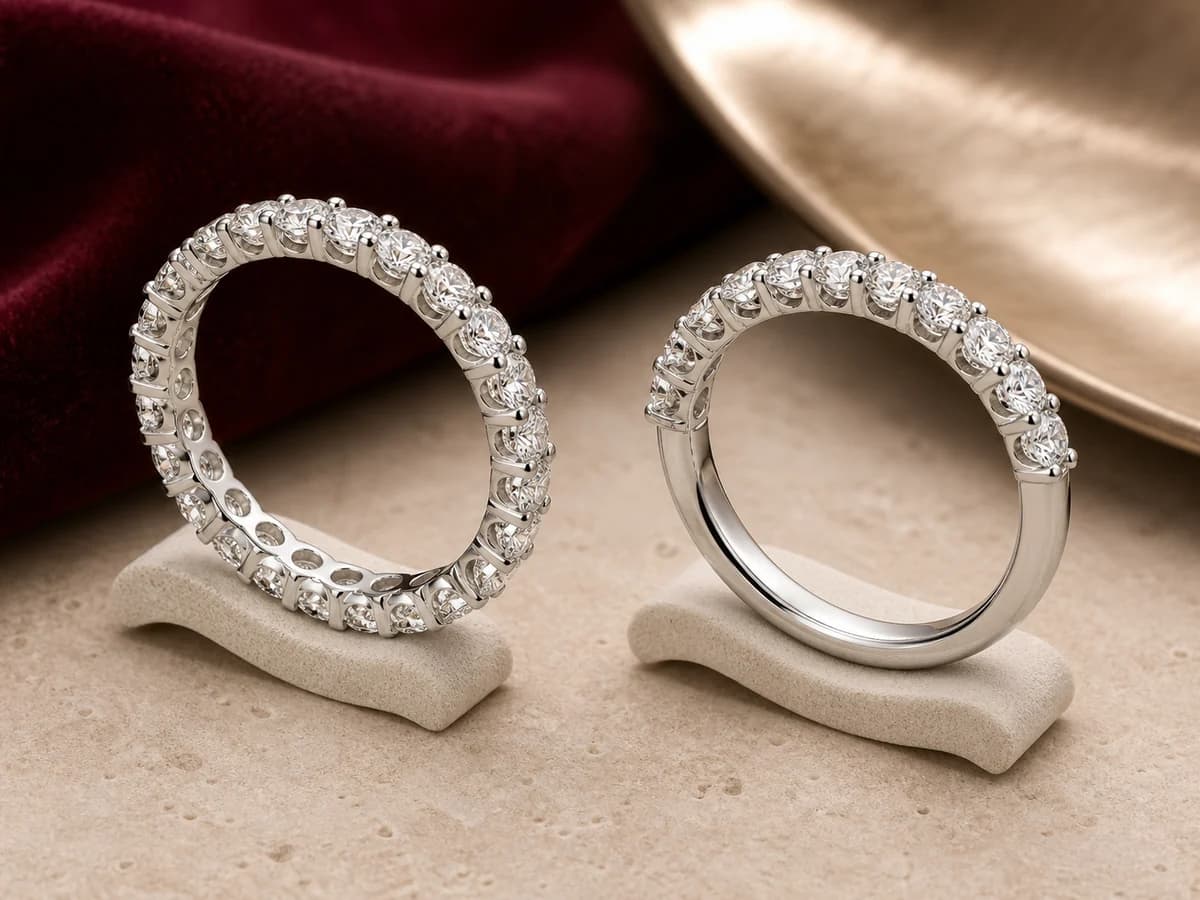 A full eternity band with continuous stones beside a half eternity band with a polished lower shank.
