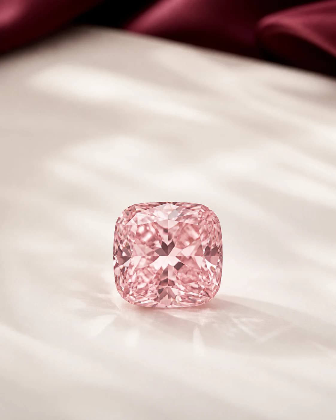 A blush pink laboratory-grown diamond in warm editorial studio light.