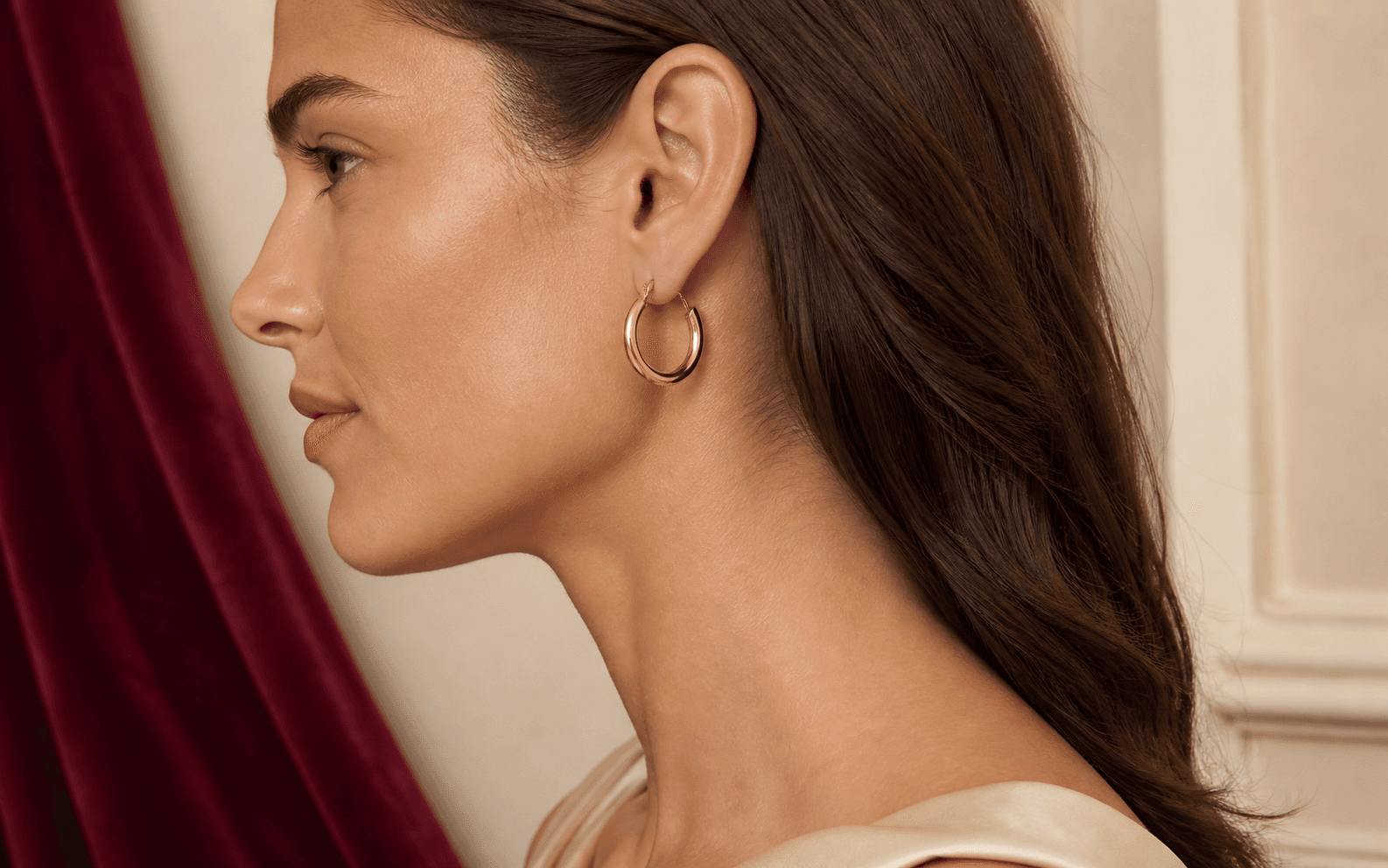 Illustrative wearer showing a polished gold hoop in natural profile