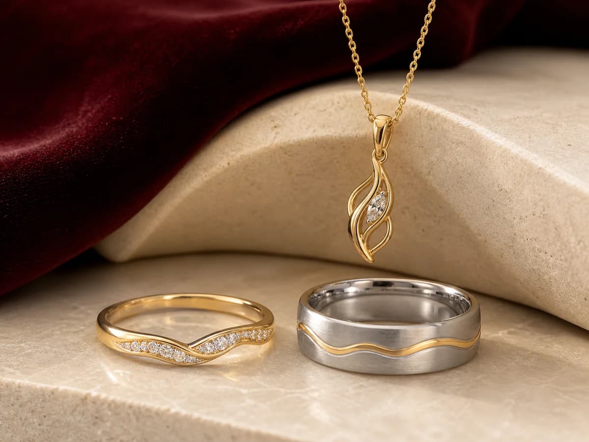 Two distinct vow-renewal band directions and a pendant connected by a quiet yellow-gold wave motif.
